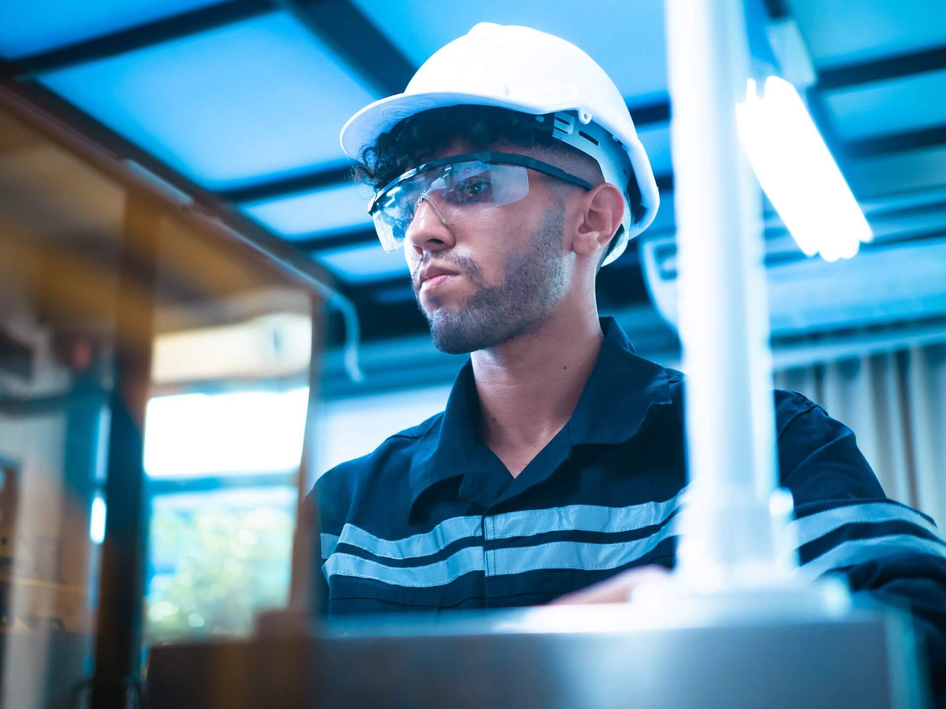 Empleado vistiendo su uniforme empresarial y realizando controles rutinarios en su trabajo